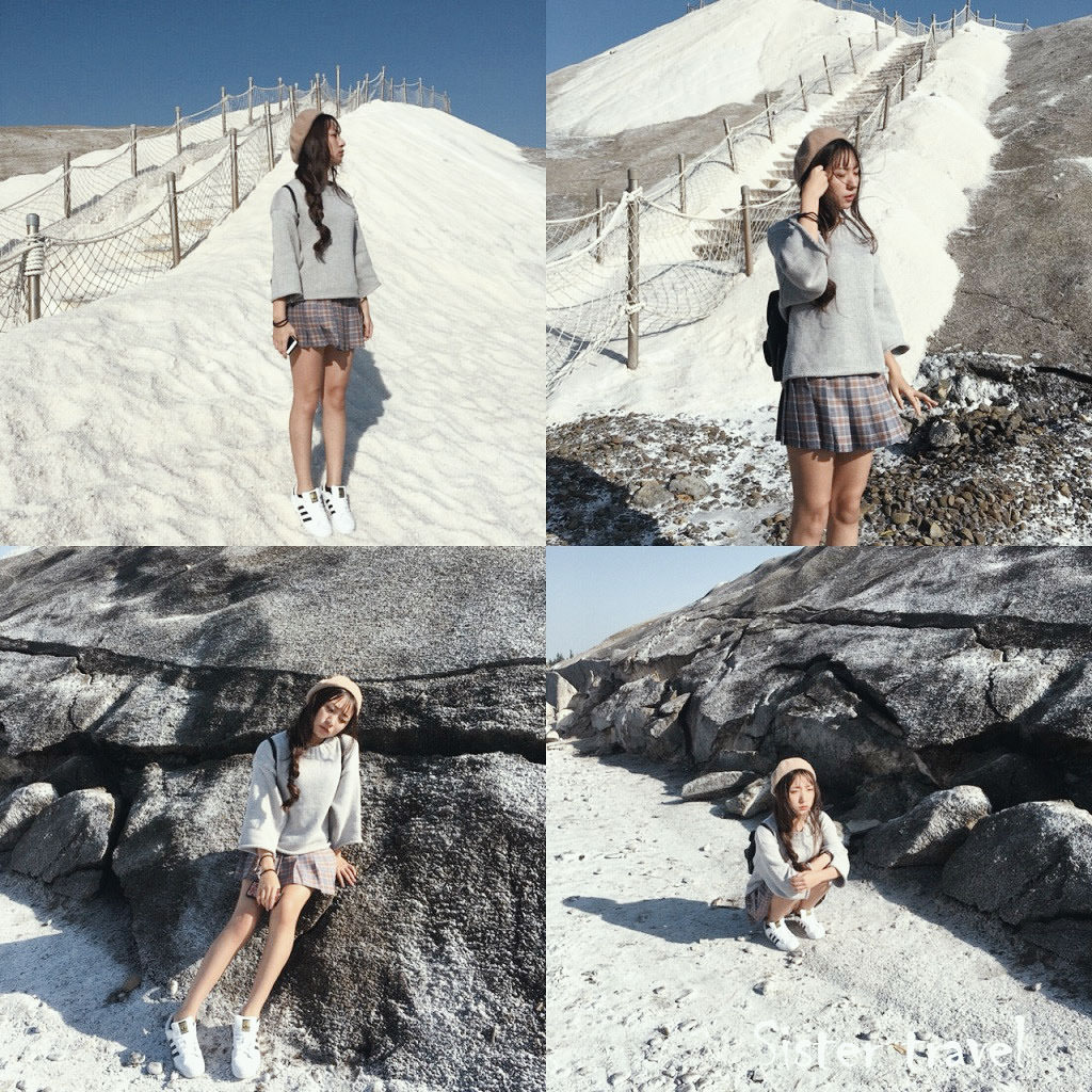 一個穿著短裙帶著貝雷帽的女孩站在鹽山上拍照